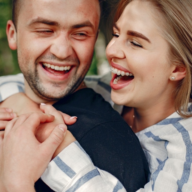 Woman with adult orthodontics smiling with a man outdoors