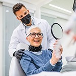 Woman smiling at reflection in handheld mirror