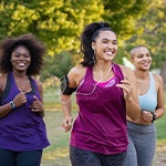 Group of women smiling while jogging in park