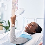 Woman smiling while looking at reflection in mirror