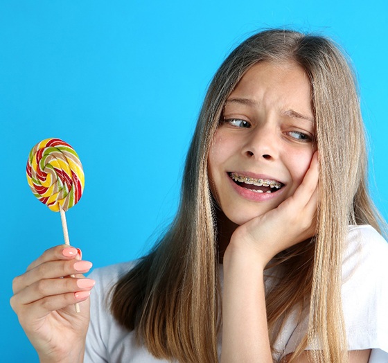 Pained girl with lollipop and broken braces in Palm harbor 