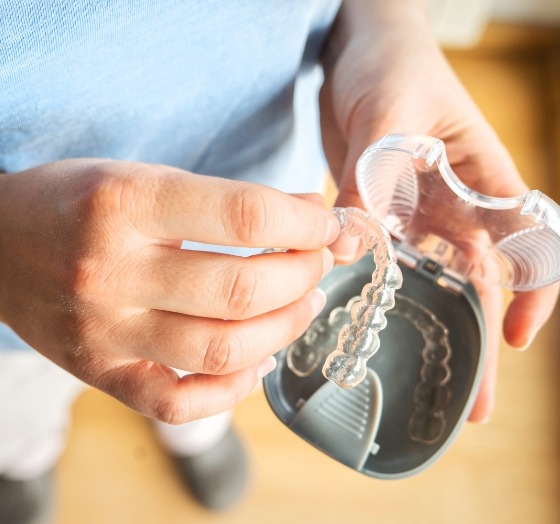 Patient taking Invisalign tray out of carrying case