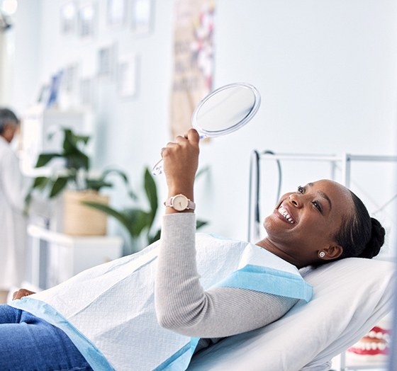 Woman smiling while looking at reflection in mirror