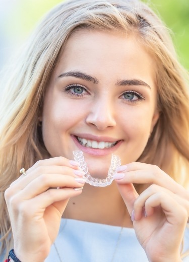 Woman holding her Nyce smile aligner tray