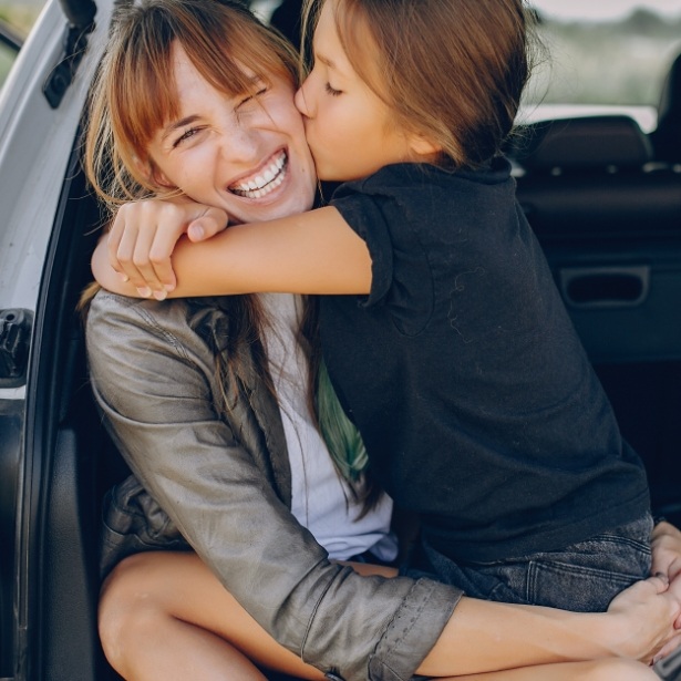 Child kissing mother on cheek after orthodontic office visit