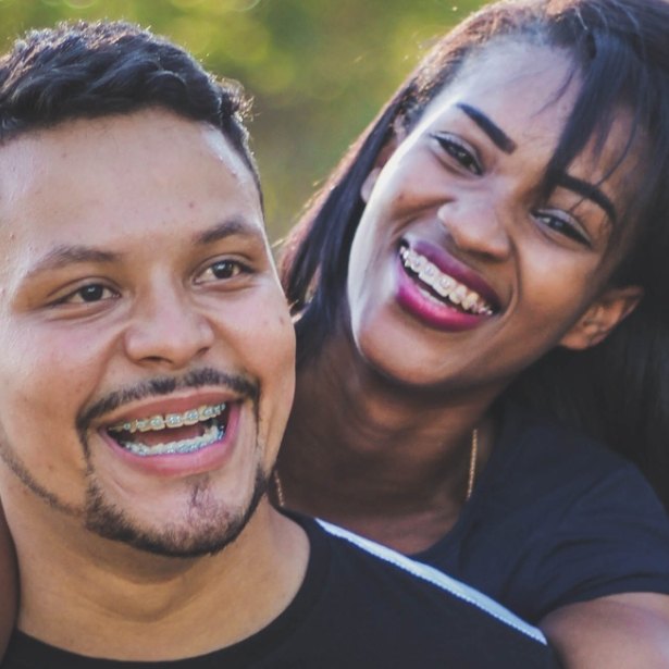 Young man and woman with traditional braces smiling