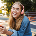 Teen girl smiling while listening to music outside