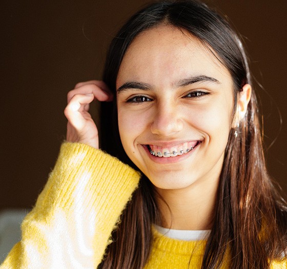 Teen girl in yellow sweater with traditional braces in Palm Harbor, FL