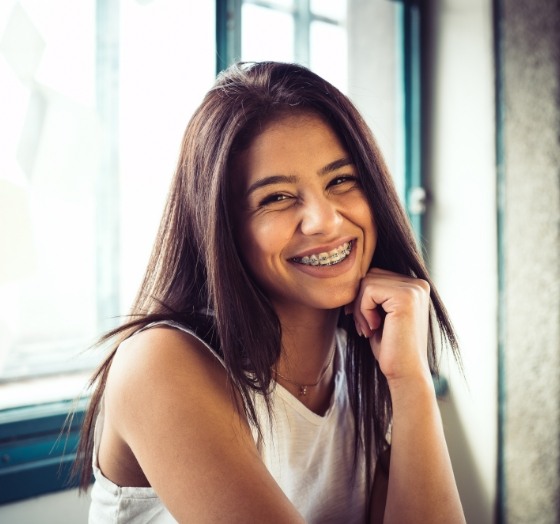 Young woman with traditional braces smiling