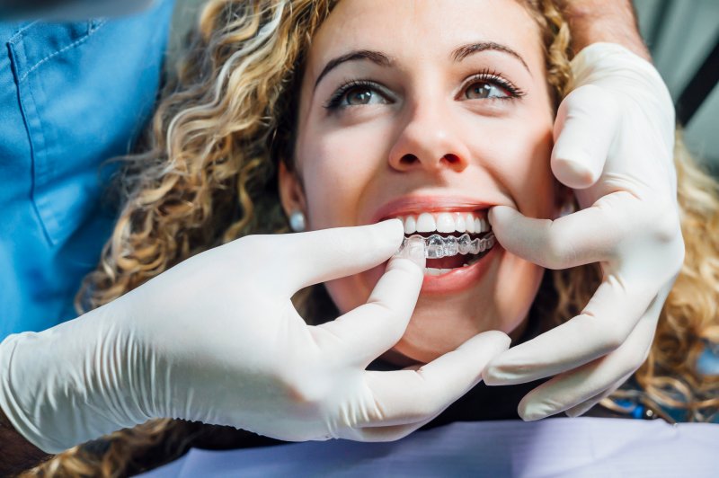 A woman receiving an Invisalign tray