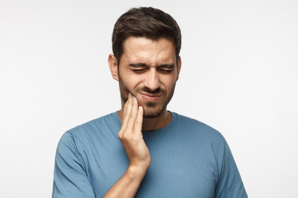 closeup of person in blue shirt with jaw pain