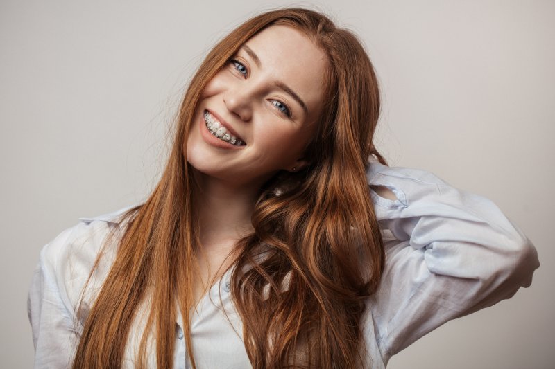 a young woman smiling with ceramic braces