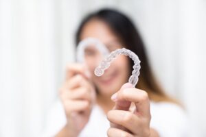 Woman holding up her Nyce Smile Aligners
