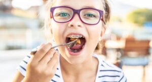 Child with braces eating lunch